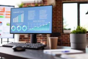 Monitor with charts. Computer showing diagram and graph used for advertising on desk in empty office. Analytics research report in space.