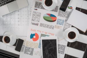top view of business documents on workplace with digital devices and coffee
